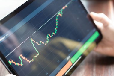 Kapalı el, dijital tablet bilgisayarı ile ticaret platformu için ikili seçeneğin grafiği, sıralı odak