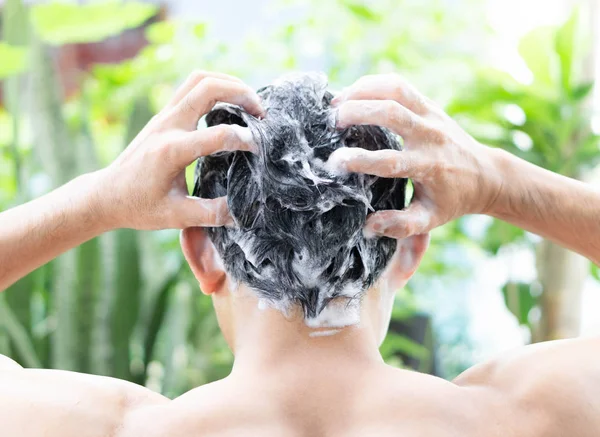 Nahaufnahme junger Mann beim Haarewaschen mit Shampoo aus dem Freien, Gesundheitskonzept, selektiver Fokus — Stockfoto