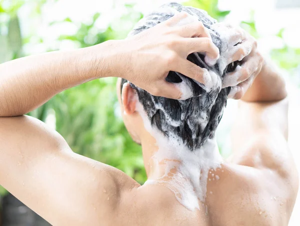 Closeup jovem homem lavar cabelo com shampoo de exterior, conceito de cuidados de saúde, foco seletivo — Fotografia de Stock