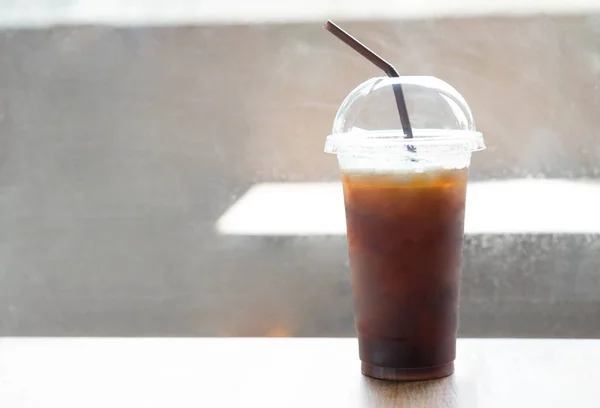 Закрыть лед американо на фоне деревянного стола в кофейне — стоковое фото