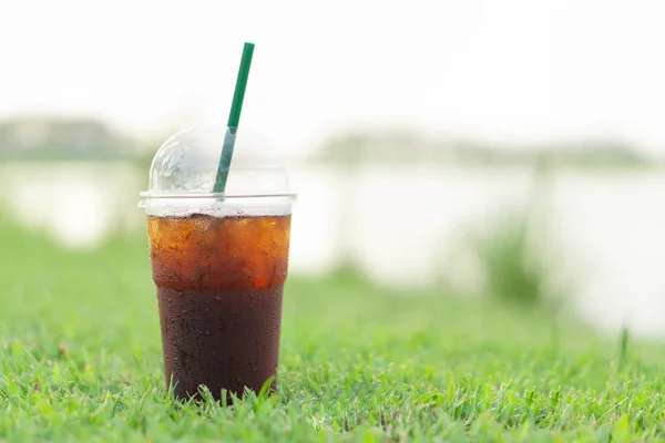 Zamknij szklankę lodu americano kawy z zielonym tle trawy przyrody, selektywne skupienie — Zdjęcie stockowe