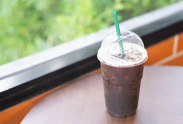 Primer plano vaso de hielo americano café sobre mesa de madera en cafetería, enfoque selectivo —  Fotos de Stock