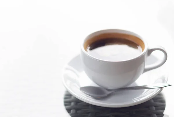 Nahaufnahme heißer Amerikanischer Kaffee auf Glastisch mit überhellem, selektivem Fokus — Stockfoto