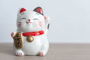Ahşap masa arka planda Maneki Neko, odak seçin