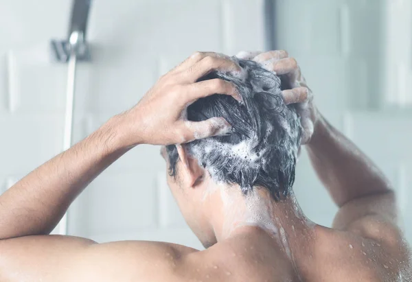 Nahaufnahme junger Mann beim Haarewaschen mit Shampoo im Badezimmer, Vintage-Ton, selektiver Fokus — Stockfoto