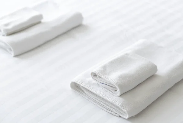 Primer plano toalla nueva en la cama blanca — Foto de Stock