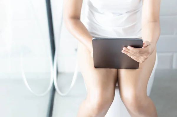 Fermer femme assise sur les toilettes et en utilisant tablette PC avec sensation de détente le matin, foyer sélectif — Photo