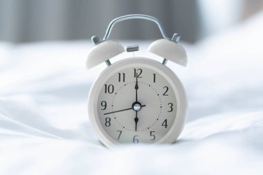 Pencereden ışık ile beyaz kötü üzerinde çalar saat, seçici odak