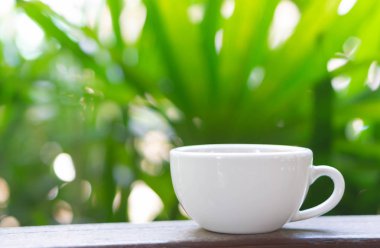 Yeşil doğa arka plan ile cam masada Closeup sıcak americano kahve