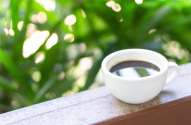 Yeşil doğa arka plan ile cam masada Closeup sıcak americano kahve