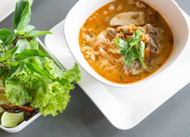 Erişteli pilav çorbası ve karaciğer çorbası masada, seçici bir odak noktası.