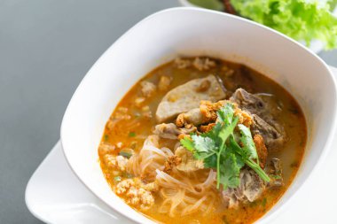 Erişteli pilav çorbası ve karaciğer çorbası masada, seçici bir odak noktası.