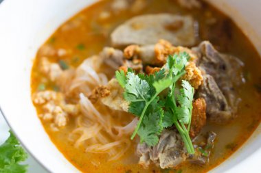 Erişteli pilav çorbası ve karaciğer çorbası masada, seçici bir odak noktası.