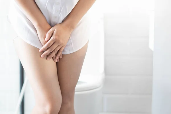 Close-up vrouw buikpijn met toilet in de ochtend, gezondheidszorg concept, selectieve focus — Stockfoto