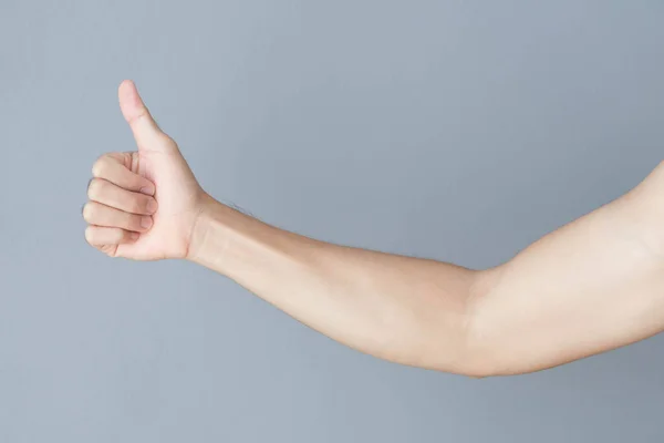 Young man hand thumbs up for good feeling with grey background — Stock Photo, Image