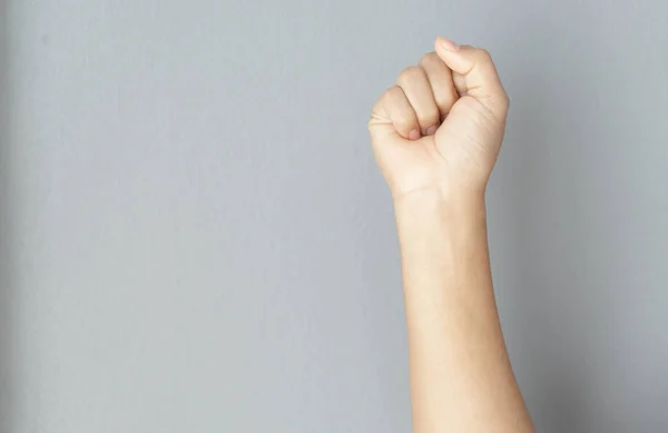 Woman hand with clenched fist on grey background — Stock Photo, Image