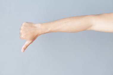 Gri arka planda adam el başparmak aşağı işareti