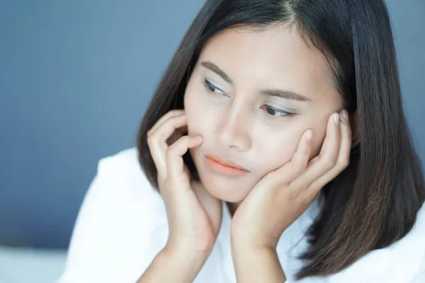 Nahaufnahme Frau sitzt auf dem Bett im Schlafzimmer mit Denken oder deprimiertem Gefühl, selektiver Fokus — Stockfoto