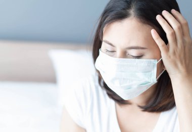 Beyaz yatakta yatan tıbbi maske yüzü takan hasta kadını kapatın, sağlık hizmetleri ve konsept