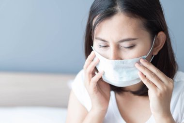 Beyaz yatakta yatan tıbbi maske yüzü takan hasta kadını kapatın, sağlık hizmetleri ve konsept