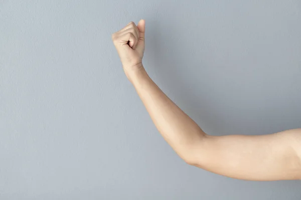 Woman hand with clenched fist on grey background, health care and medical concept — Stock Photo, Image