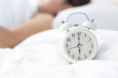 Yatak ve el tutma alarmı saat, uyanma zamanı üzerinde uyuyan kapatmak kadın