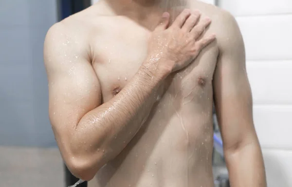 Primer plano guapo asiático hombre tomando una ducha en el baño, enfoque selectivo — Foto de Stock