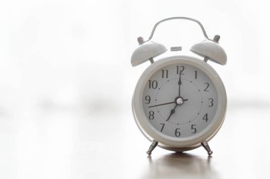 Pencereden gelen ışıkla uyanma saati için ahşap masadaki alarm saati, seçici odak