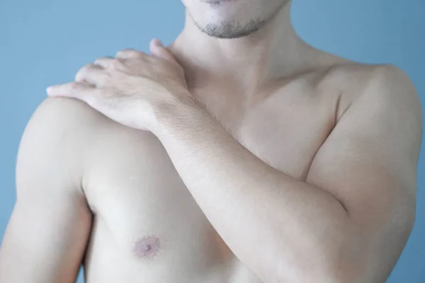 Closeup homem mão segurando ombro com dor no fundo cinza — Fotografia de Stock