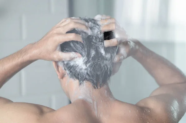 Nahaufnahme junger Mann beim Haarewaschen mit Shampoo im Badezimmer, Vintage-Ton, selektiver Fokus — Stockfoto