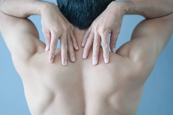 Closeup mão homem segurando ombro com dor no fundo azul, cuidados de saúde e conceito médico — Fotografia de Stock