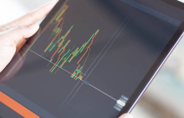 Kapalı el, dijital tablet bilgisayarı ile ticaret platformu için ikili seçeneğin grafiği, sıralı odak