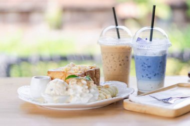 Ballı tost, ahşap masada buzlu kahve.