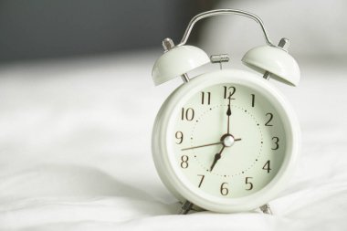 Pencereden gelen ışıkla uyanma saati için ahşap masadaki alarm saati, seçici odak