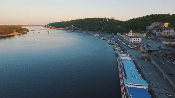 Puerto fluvial con botes en el casco antiguo de la ciudad y verdes colinas aéreas de drones disparar — Vídeos de Stock