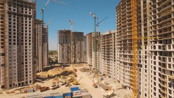 Construção de casas. Drone voar sobre canteiro de obras com guindastes de torre — Vídeo de Stock