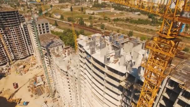 Plano aéreo de los trabajadores en una construcción, estructura en el proceso de construcción — Vídeo de stock