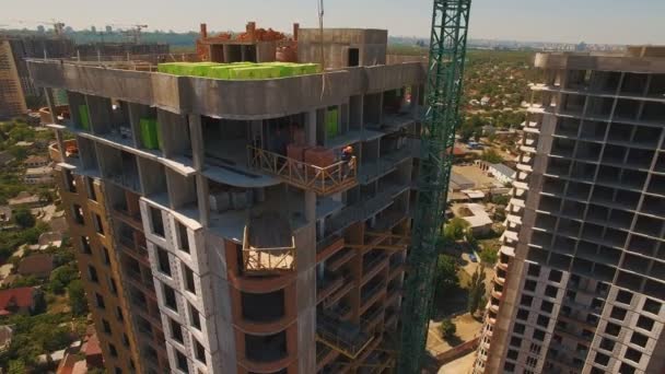 Plano aéreo de los trabajadores en una construcción, estructura en el proceso de construcción — Vídeo de stock