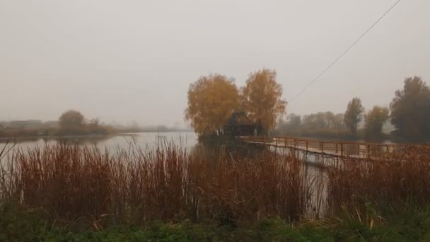 Casa de cuento de hadas en medio del lago en una antena de niebla de otoño por la mañana — Vídeos de Stock