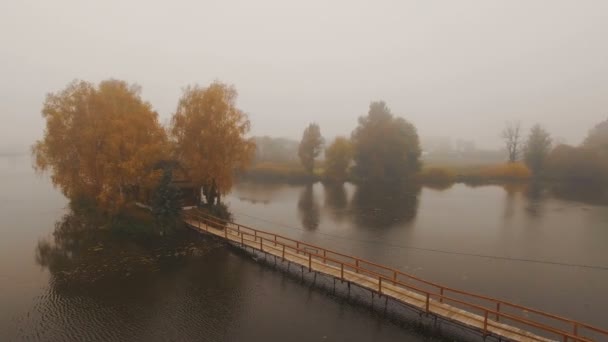 Maison de conte de fées au milieu du lac par un matin brumeux d'automne aérienne — Video