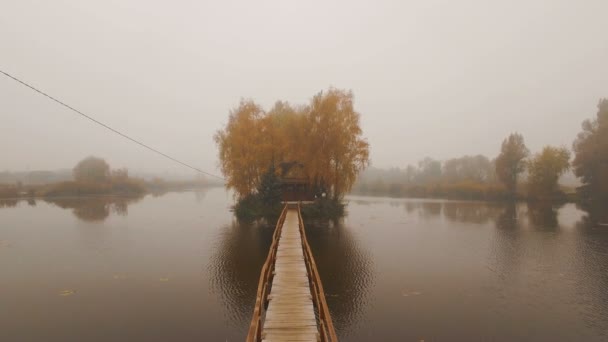 Casa de cuento de hadas en medio del lago en una antena de niebla de otoño por la mañana — Vídeo de stock