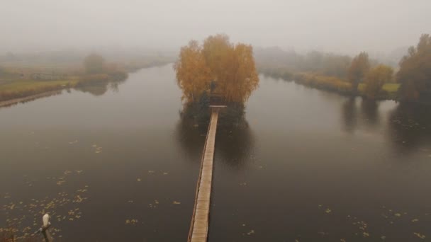 Παραμυθένιο σπίτι στη μέση της λίμνης σε μια εναέρια φθινοπωρινή ομίχλη το πρωί — Αρχείο Βίντεο