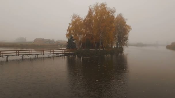 Casa de cuento de hadas en medio del lago en una antena de niebla de otoño por la mañana — Vídeo de stock
