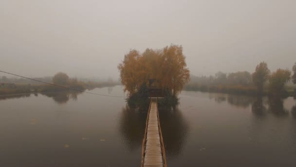 Casa de cuento de hadas en medio del lago en una antena de niebla de otoño por la mañana — Vídeos de Stock