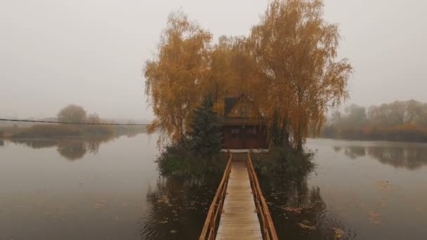 Casa de cuento de hadas en medio del lago en una antena de niebla de otoño por la mañana — Vídeos de Stock