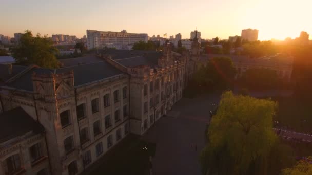 Oude universiteit op de achtergrond van de stad bij zonsondergang luchtfoto — Stockvideo