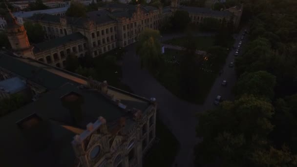 Oude universiteit op de achtergrond van de stad bij zonsondergang luchtfoto — Stockvideo