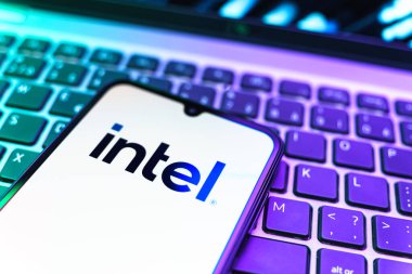 Prag, Çek Cumhuriyeti - 08 19 2025: Intel logosunu gösteren klavyenin üzerinde duran bir cep telefonunun yakından görüntüsü. Intel işlemci ve bilgisayar donanımı üreten bir teknoloji şirketidir..