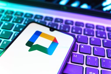 Prag, Çek Cumhuriyeti - 08 19 2025: Google Chat logosunu gösteren klavyenin üzerinde duran cep telefonunun yakından görüntüsü. Google Chat mesajlaşma ve takım işbirliği için bir platformdur.