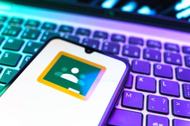 Prag, Çek Cumhuriyeti - 08 19 2025: Google Sınıfı logosunu gösteren klavyenin üzerinde duran cep telefonunun yakından görüntüsü. Google Sınıfı, sınıfları ve eğitim içeriğini yönetmek için bir platformdur.